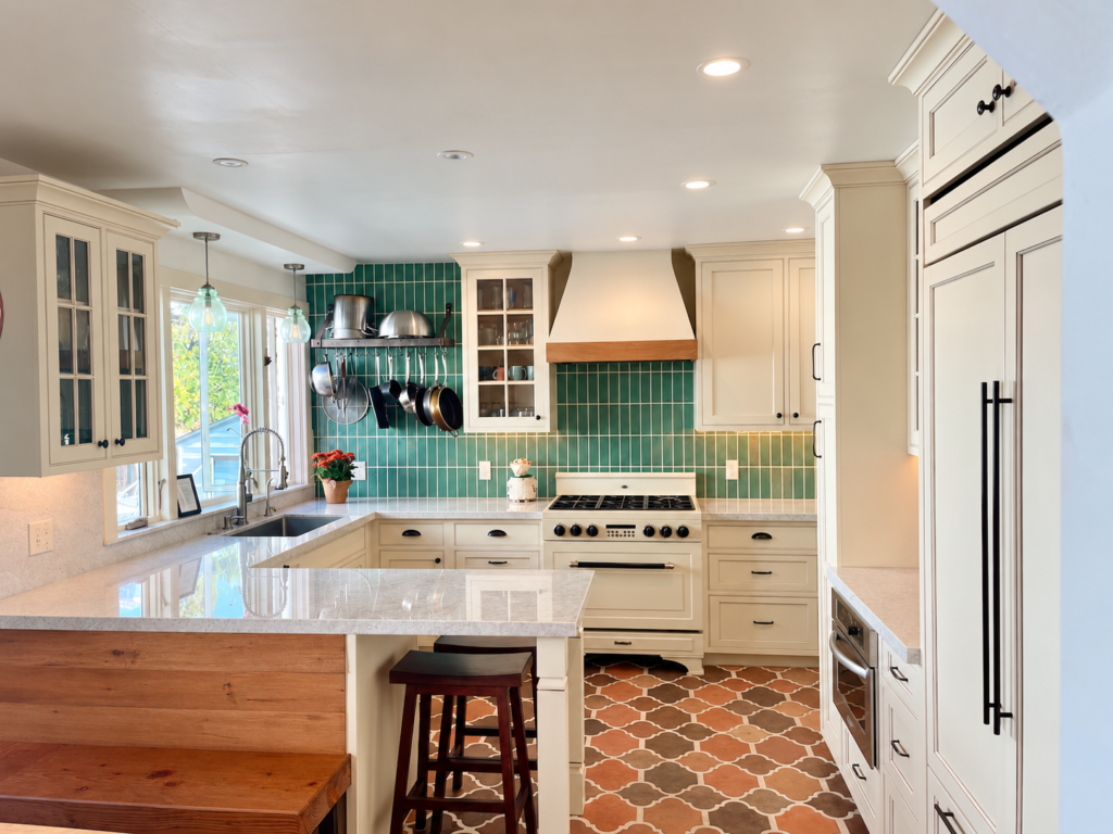 Kitchen with inset cabinetry, green and terracotta tile, and wood details